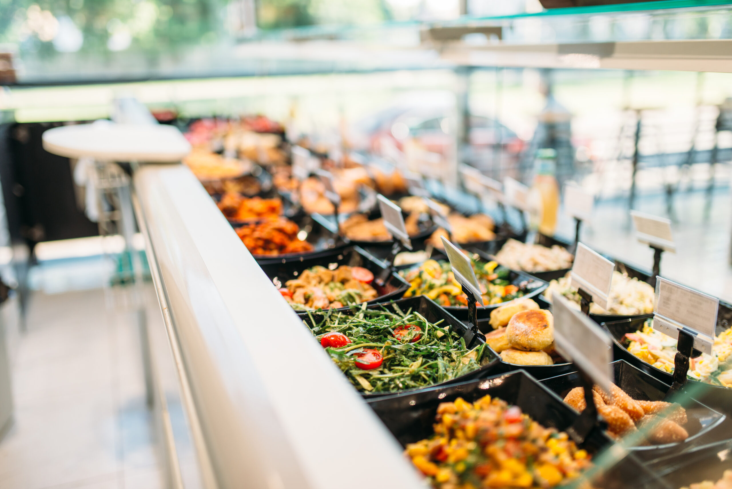 Fresh cooked food in store, nobody. Showcase with prepared salads and meat products in market