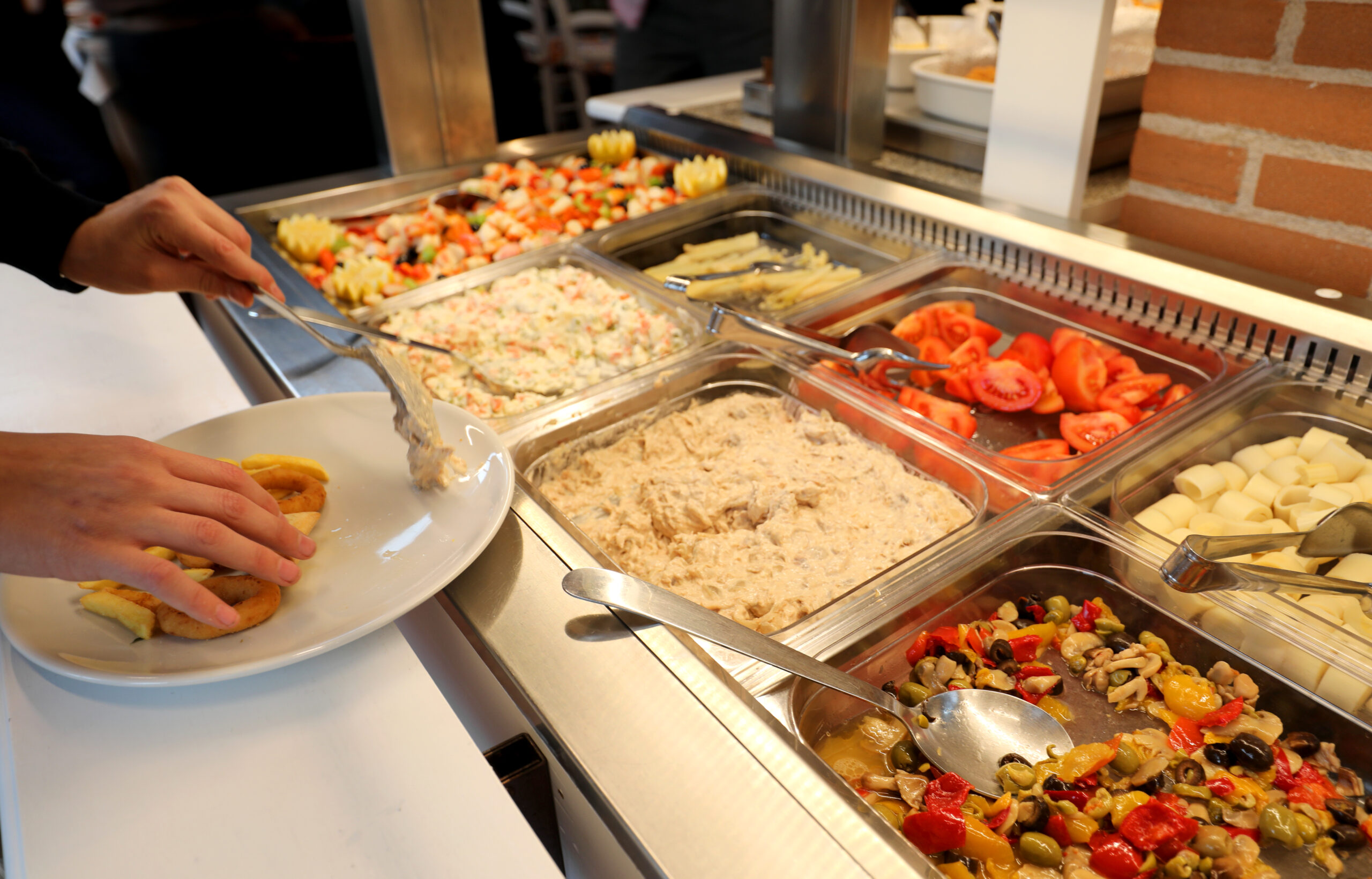 Inside a self service restaurant with many raw and cooked foods